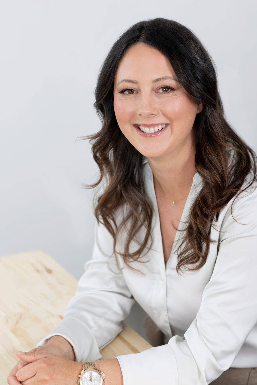 Relaxed Professional Headshots of a Consultant leaning on desk